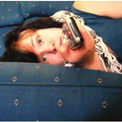 person on sofa with remote control