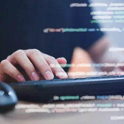 hands on keyboard and lines of code