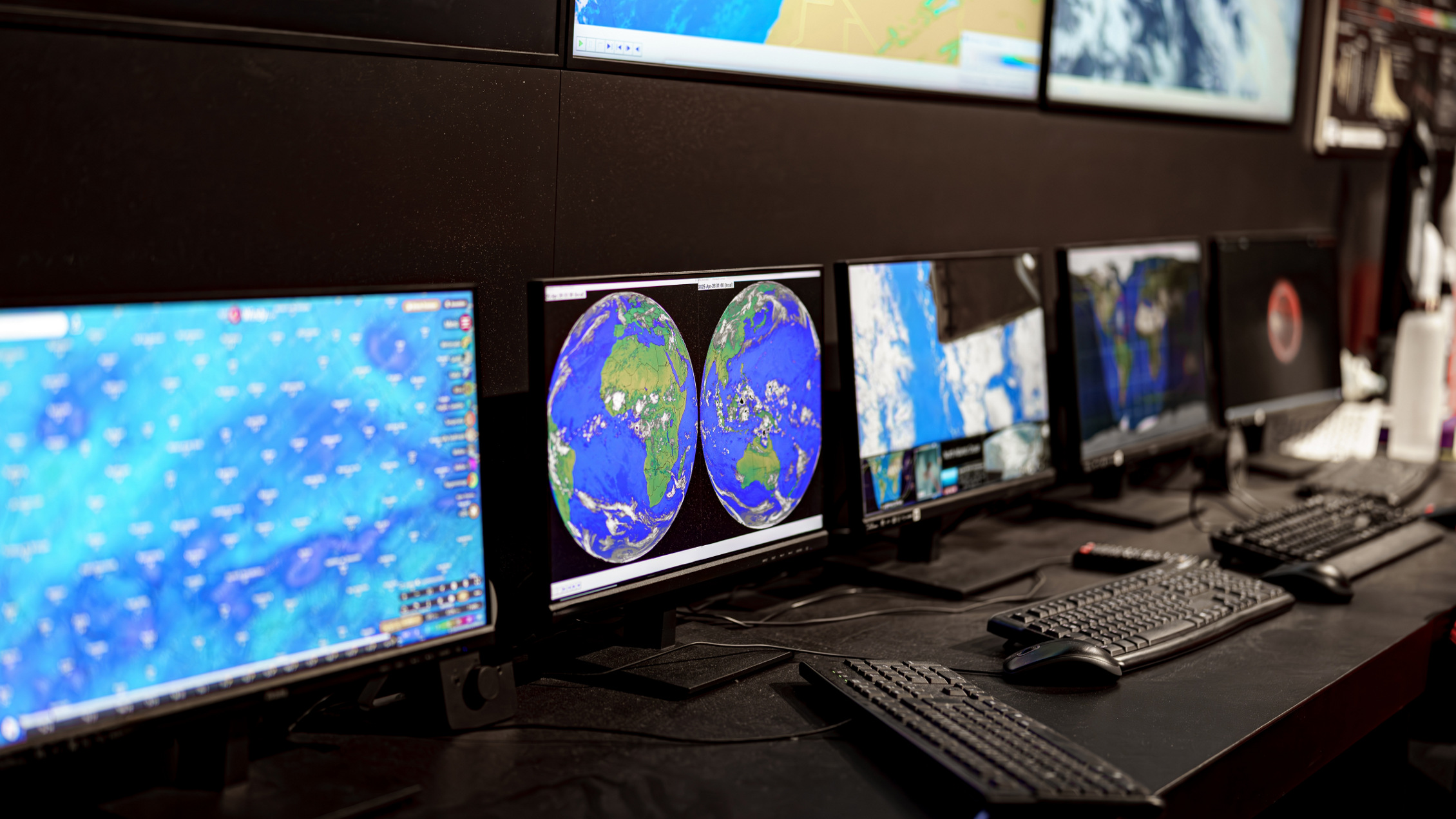 computer screens displaying weather maps